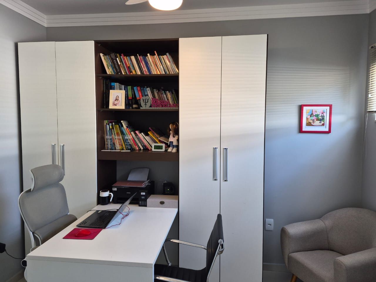 Sala de atendimento com escrivaninha e biblioteca